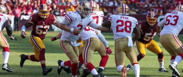 The San Francisco 49ers quarterback passes the ball to Carlos Hyde.